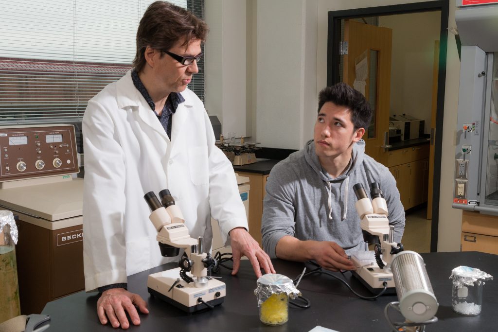 Student and professor in lab with microscopes